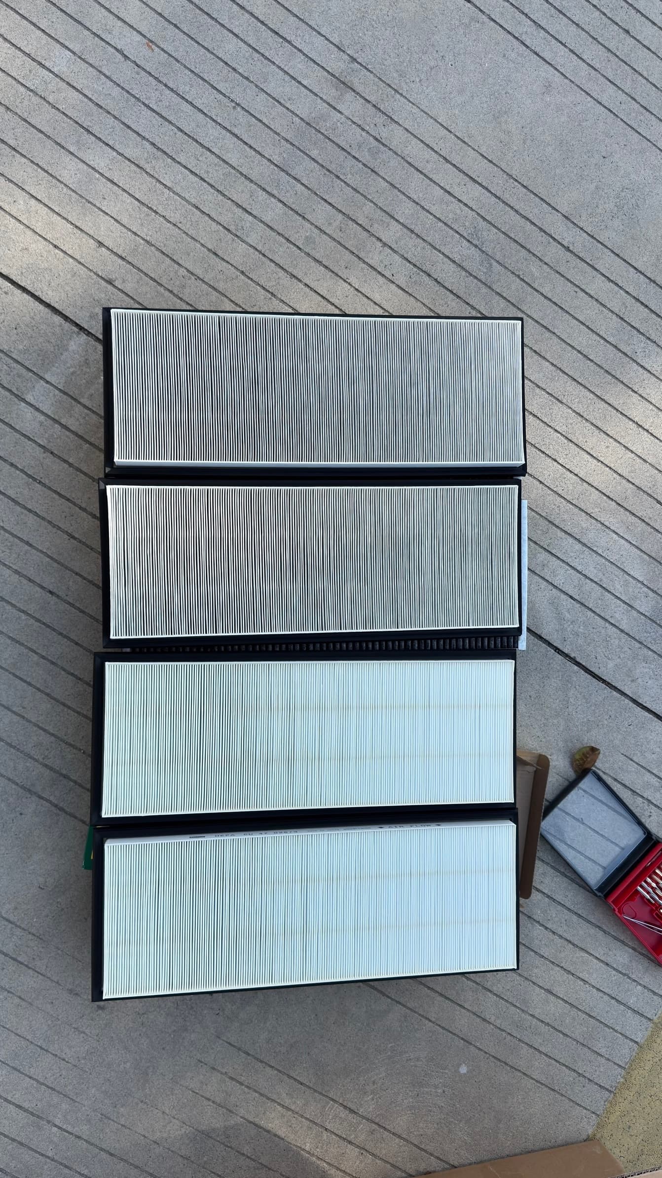 Two Model Y cabin filters photographed from above, one visibly darker and one clean