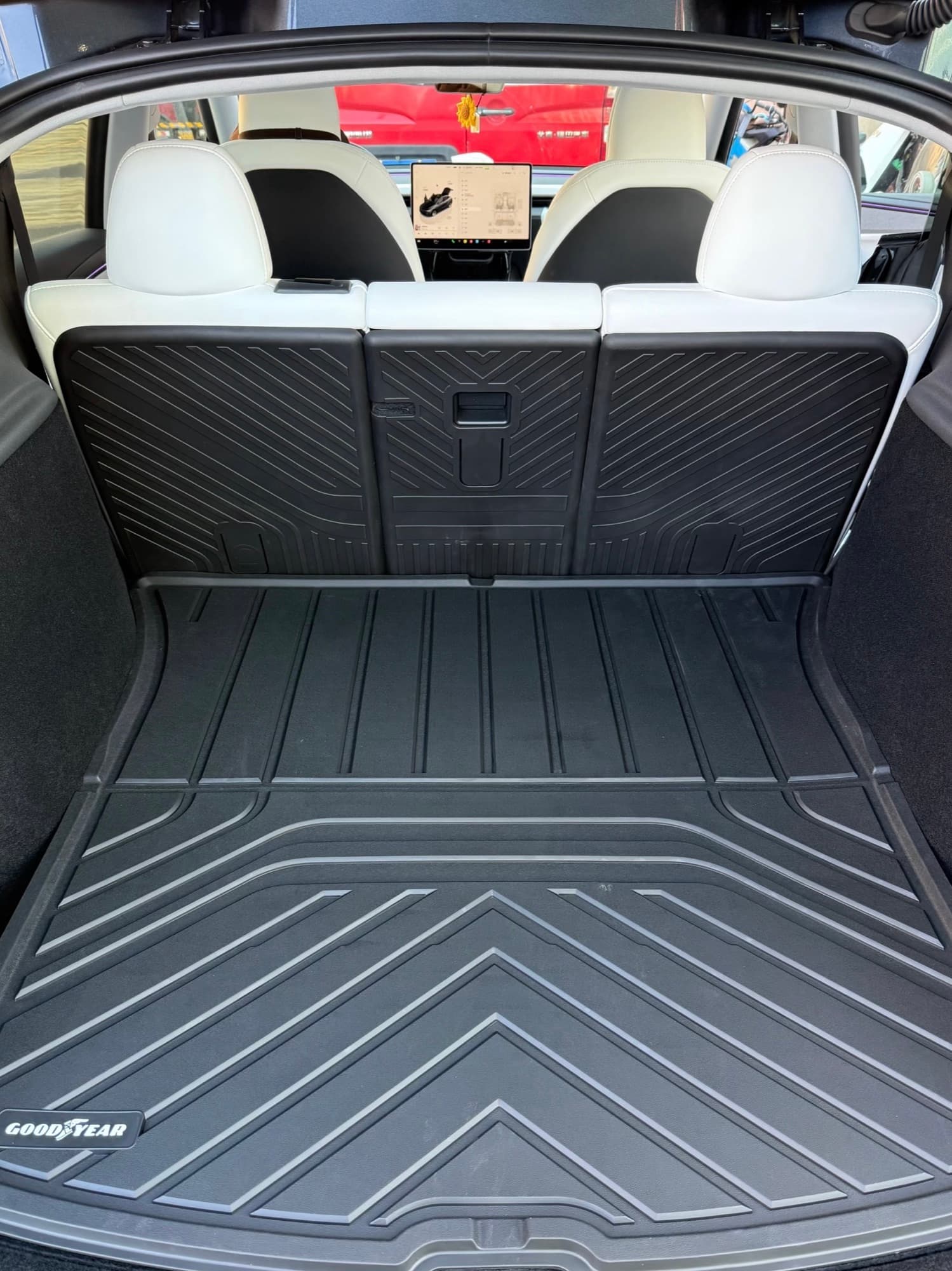 Model Y rear cargo area covered by a raised-edge floor liner and matching seatback protectors
