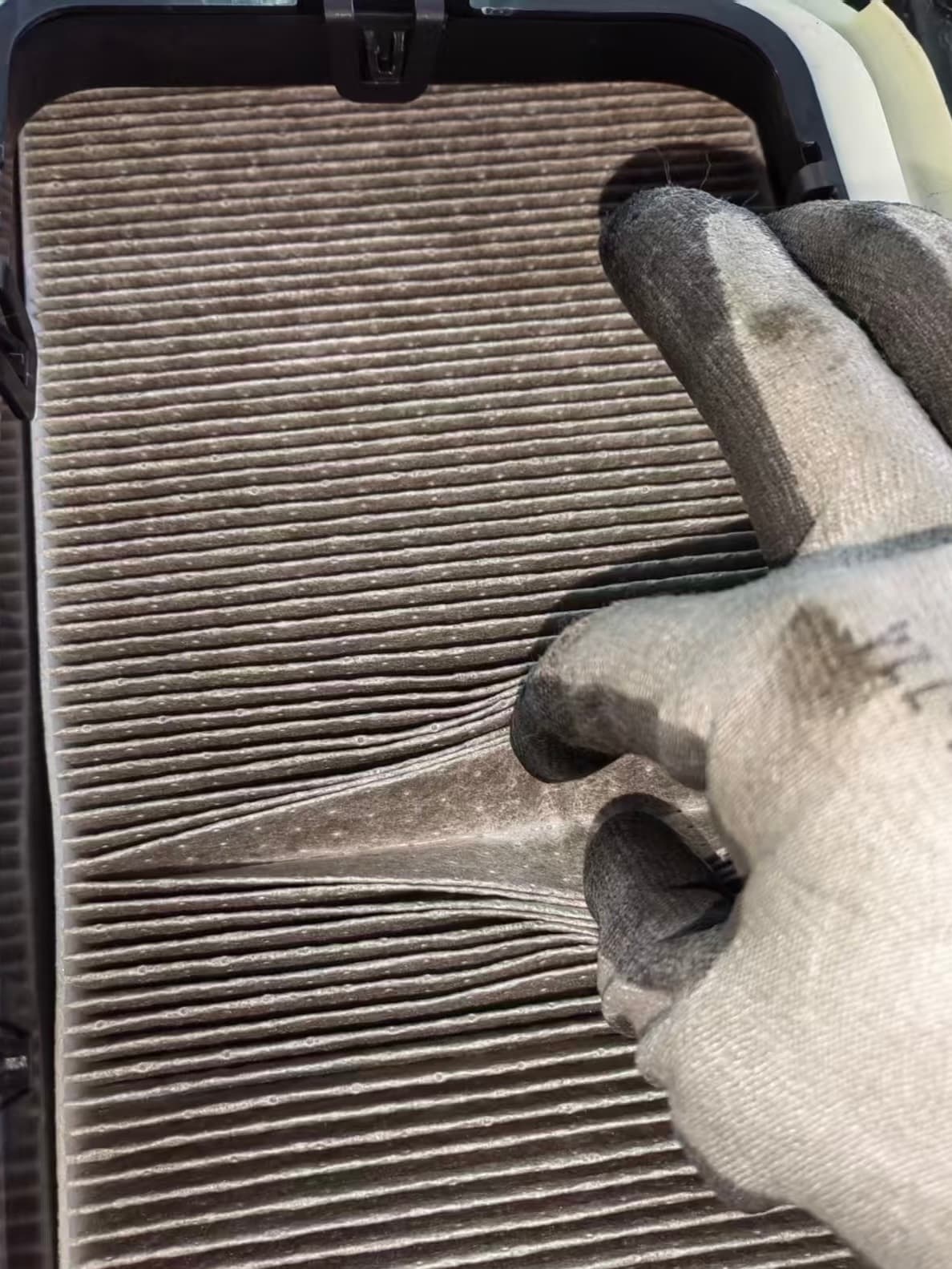Dirty Model Y cabin filter with dark debris caught in the pleats