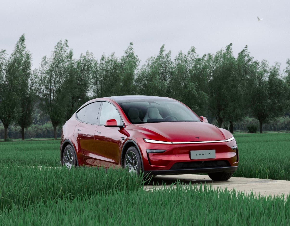 Red Model Y parked outdoors with the refreshed front lighting visible