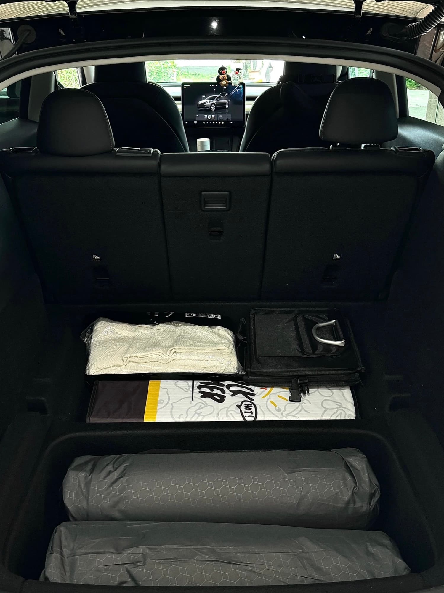 Compact camping equipment arranged in the rear cargo area of a Model Y